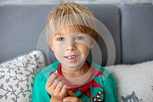 Sweet blond preschool child, boy, loosing his first milk tooth, smiling happily, holding the little tooth