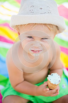 Sweet blonde toddler boy, eaiting ice cream on the beach