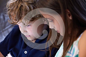 Sweet, bonding and children relax on sofa together watching video on tablet for entertainment. Cute, siblings and girl