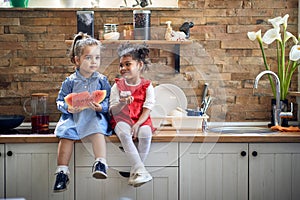 Sweet Bonds: Two Young Girls Creating Memories with Muffins and Watermelon in the Kitchen