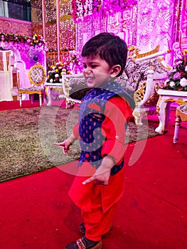 Sweet boy doing punjabi dancing step in indian traditional dress