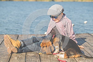 Sweet boy playing with his dog by the river