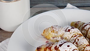 Sweet breakfast on the table. Cup of coffee and delicious croissants on the plate