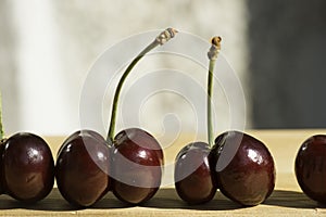 Sweet bright red cherries places on a wooden board close up photo
