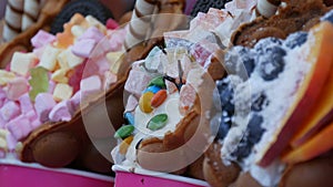 Sweet bubble Hong Kong waffles with marshmallows, chocolate, candies with berries and blueberries and marmalade on the