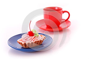 Sweet cake with cherry with red cup isolated