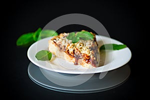 Sweet cake with fruit jam in a plate on a black