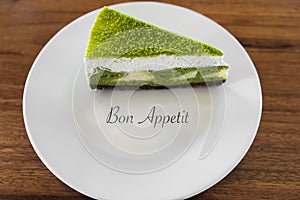 Sweet cake, green color cake, the White plate with pirodeny, a dessert.