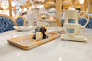 Sweet cake, Teapot and cup put on table in cafe