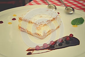 Sweet caloric papal fondant served with on white plate with fruit with a silver steel spoon