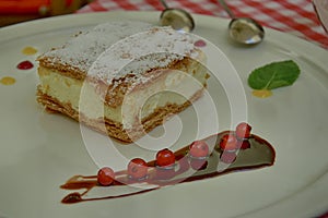 Sweet caloric papal fondant served with on white plate with fruit with a silver steel spoon