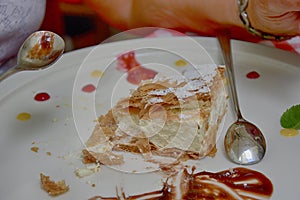 Sweet caloric papal fondant served with on white plate with fruit with a silver steel spoon