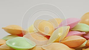 Sweet candies in the shape of a UFO in different colors rotate on a white background.
