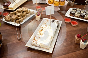 Sweet candy bar.Different delicious fruits and cakes on wedding reception table . photo