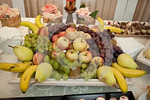 Sweet candy bar.Different delicious fruits and cookies on wedding reception table with bananas and grapes