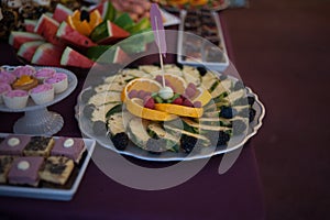 Sweet candy bar.Different delicious fruits and cookies on wedding reception table with bananas and grapes photo