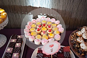 Sweet candy bar.Different delicious fruits and cookies on wedding reception table with bananas and grapes photo