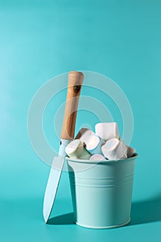 Sweet candy marshmallows  in  turquoise bucket and little kids shovel