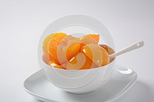 Sweet canned peaches in the ceramic bowl