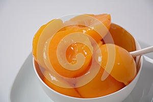 Sweet canned peaches in the ceramic bowl