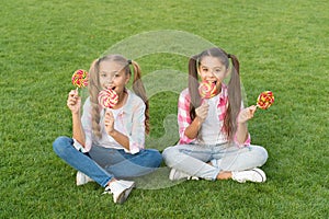 Sweet caramel. Happy children hold candy sit grass. Candy shop. Lollipop treats. Candy means happiness. Sugar and