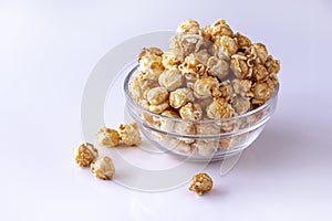 Sweet caramel popcorn in glass bowl. Close up. White background. Isolate