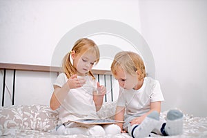Sweet caucasian children use modern gadget, holding tablet in hands