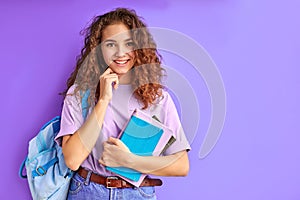 Sweet caucasian friendly young student girl holding colorful exercise books.