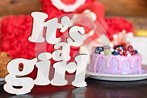 Sweet cheese cake with fresh berries and yoghurt cream and wooden sign Its A Girl. Baby shower party sweets.