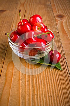 Sweet cherries (Prunus avium) in plate on wooden board