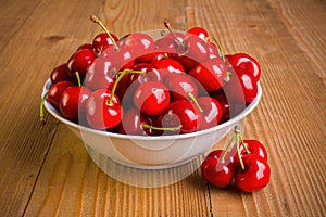 Sweet cherries (Prunus avium) in plate on wooden board