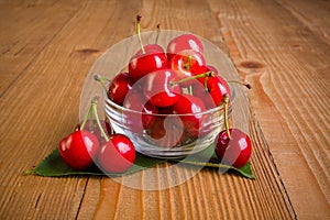 Sweet cherries (Prunus avium) in plate on wooden board