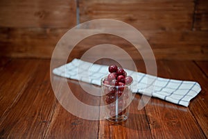 Sweet cherry, black cherries in a glass on wooden background