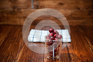 Sweet cherry, black cherries in a glass on wooden background