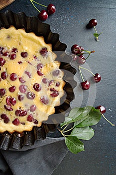 Sweet cherry clafouti on dark background. Top view