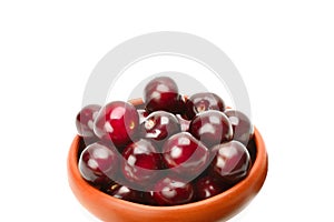 Sweet cherry in a clay bowl isolated on white background. Place for your text