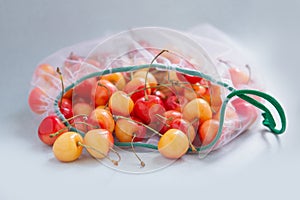 Sweet cherry in eco-friendly packaging. Reusable bags for vegetables and fruits. Shopping in the store, retail. Eco-friendly