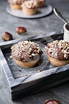 Sweet chestnut cups filled with soft curd cheese, chestnut puree and ground almonds, topped with chocolate frosting and chopped nu