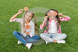 Sweet childhood. Happy children hold candy sit green grass. Candy shop. Lollipop treats. Candy synonym for happiness