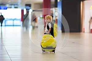 Sweet childre, brothers, boys, waking hand in hand at the airport, carrying suitcases and backpacks