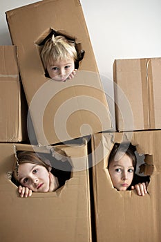 Sweet children,  boy brothers, hiding in cardboard box, looking out, isolated, sad kids, staying at home, due to quarantine