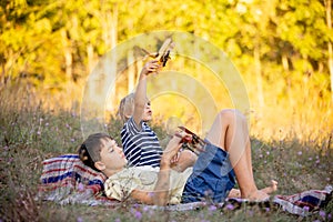 Sweet children, boys, playing in the park on sunset, autumn