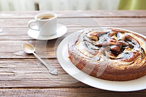 Sweet chocolate cake. Delicious chocolate cake in white plate with cup of coffee on wooden table background, close-up