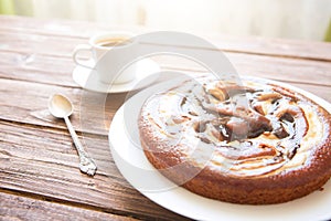 Sweet chocolate cake. Delicious chocolate cake in white plate with cup of coffee on wooden table background, close-up