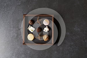 Sweet chocolate candies in wooden box, close-up. A set of assorted chocolates