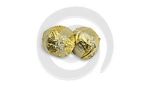 Sweet chocolate candy wrapped In golden foil papper on white background.