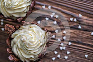 Sweet chocolate desserts with white hearts on wooden background, valentines or wedding cake, love