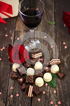 Sweet chocolate pralines, red roses and wine