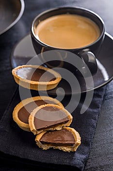 Sweet chocolate tartelettes on black table