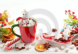 Sweet Christmas homemade treats for festive party. Hot chocolate with marshmallow snowman, gingerbread, candy cane and winter